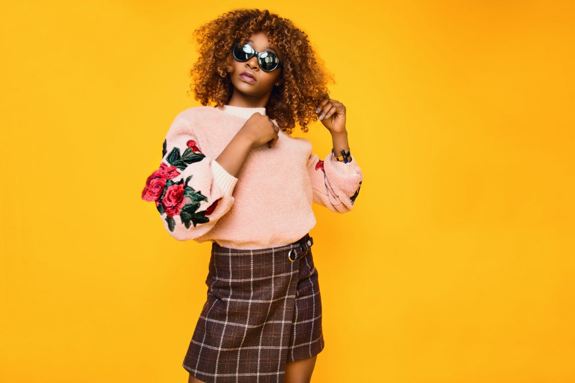 women‘s pink sweatshirt and brown plaid skirt