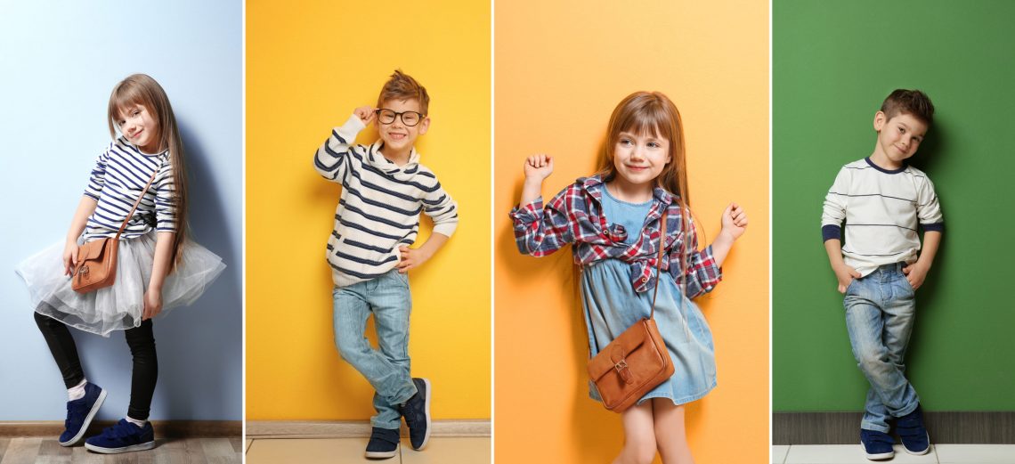 Cute stylish boy near color wall