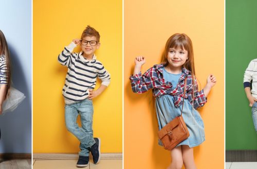 Cute stylish boy near color wall